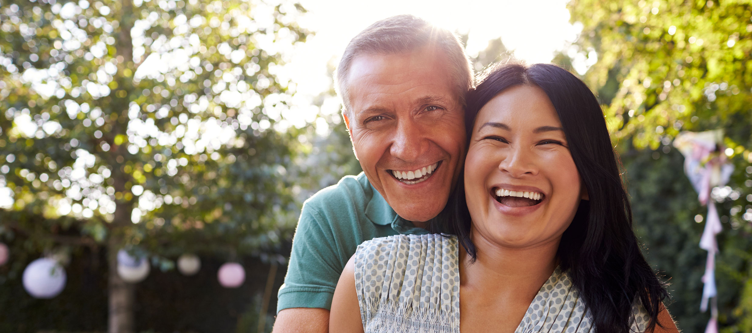 Smiling man embraces a smiling woman