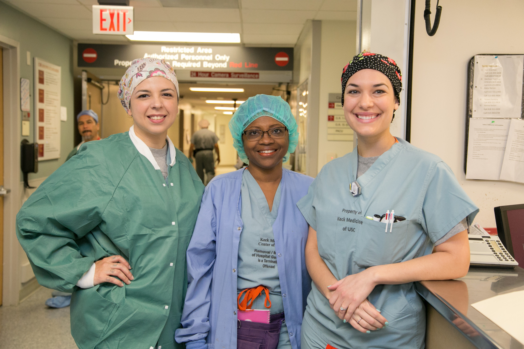 Smiling nurses in a hallway.