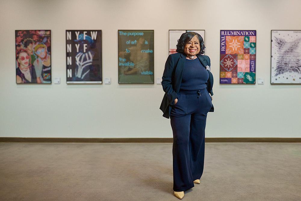 Cora Jackson-Fossett, an older black woman in a blue suit, smiles in an art gallery