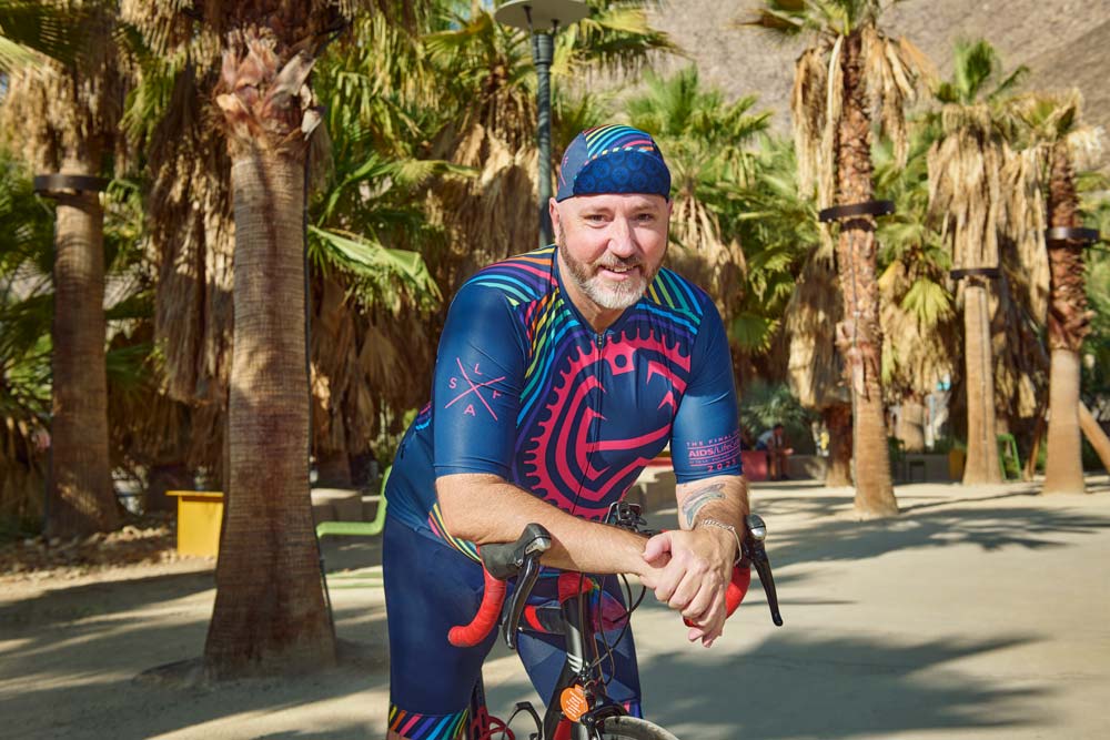 Daniel LeBlanc, a white man with a beard, leans over the handlebars of his bicycle
